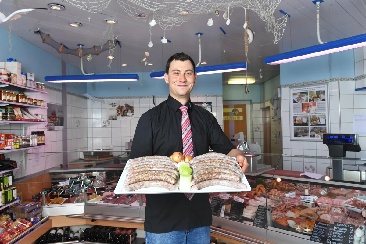 Mann mit mehreren Würsten auf einem Tablett.